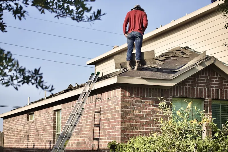 Professional roofer working on a residential roof in Friendship